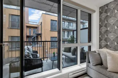 a living room with a large window with a couch at Flat at the Foot of the Mountain With Parking in Montréal