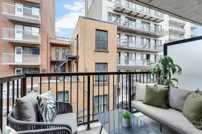 a balcony with two couches and a glass table at Flat at the Foot of the Mountain With Parking in Montréal