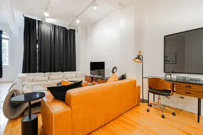 a living room with a couch and a tv at Loft Spacieux Down Town in Montréal