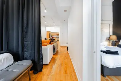 a bedroom with two beds and a living room at Loft Spacieux Down Town in Montréal