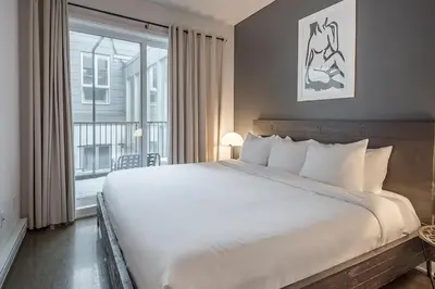a bedroom with a large white bed and a window at Luxury Old Montreal Suite with Soaring Ceilings in Montréal