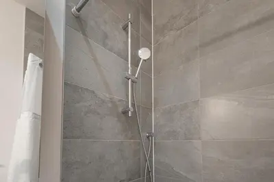 a shower with a glass door in a bathroom at Luxury Old Montreal Suite with Soaring Ceilings in Montréal