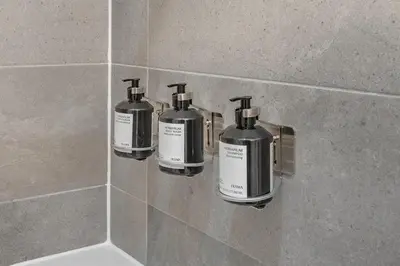 three soap bottles on a wall in a bathroom at Luxury Old Montreal Suite with Soaring Ceilings in Montréal