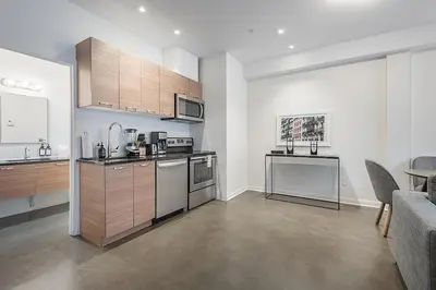 a kitchen with stainless steel appliances and wooden cabinets at Luxury Old Montreal Suite with Soaring Ceilings in Montréal