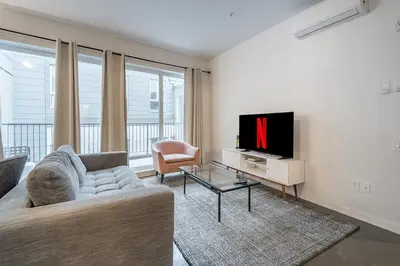 a living room with a couch and a tv at Luxury Old Montreal Suite with Soaring Ceilings in Montréal