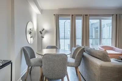 a living room with a couch and a table and chairs at Luxury Old Montreal Suite with Soaring Ceilings in Montréal