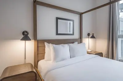 a bedroom with a large white bed and a window at Old Montreal Penthouse Iconic Location in Montréal
