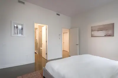 a white bedroom with a bed and a hallway at Old Montreal Penthouse Iconic Location in Montréal