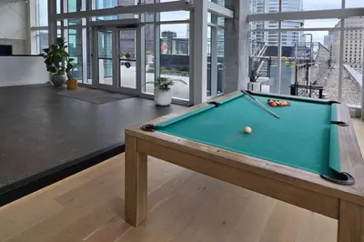 a pool table in the middle of a room at Pet-Friendly Furnished 1B Rental in Montreal with Skyline Views & Concierge in Montréal