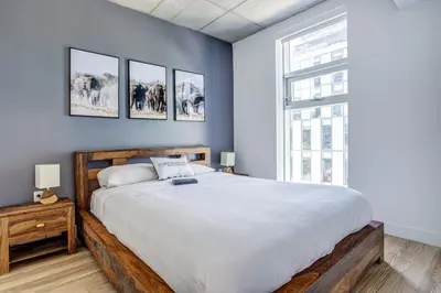 a bedroom with a large bed and a window at Pet-Friendly Furnished 1B Rental in Montreal with Skyline Views & Concierge in Montréal