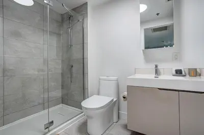 a bathroom with a shower and a toilet and a sink at Pet-Friendly Furnished 1B Rental in Montreal with Skyline Views & Concierge in Montréal