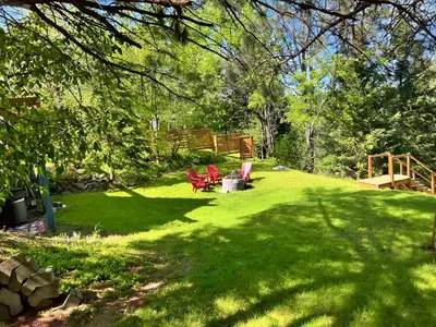 a yard with red chairs on the grass at Waterfront with Spa - Le Retro in Windsor
