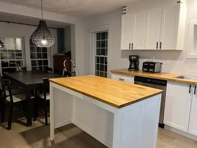 a kitchen with white cabinets and a wooden counter top at Lake Access - Private Spa - Pool table - Rustique in Windsor