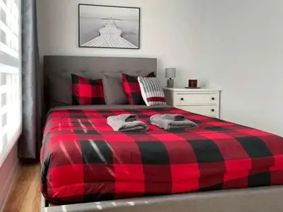 a red and black plaid bed in a bedroom at Lake Access - Private Spa - Pool table - Rustique in Windsor