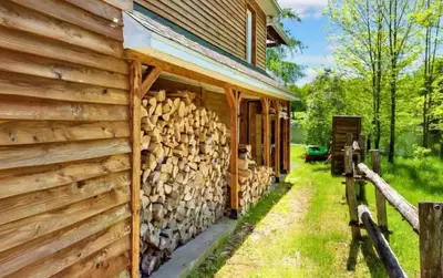 a pile of logs next to a house at Lake Access - Private Spa - Pool table - Rustique in Windsor