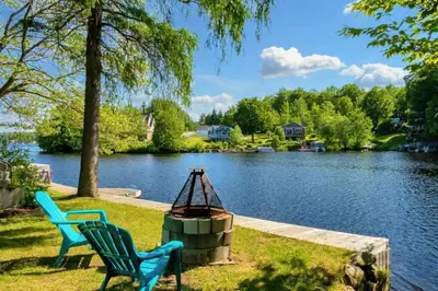 two chairs sitting on the grass near a lake at Lake Access - Private Spa - Pool table - Rustique in Windsor