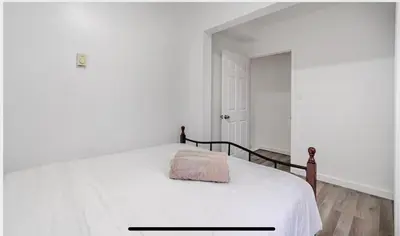 a white bedroom with a bed with a pink blanket on it at Comfortable 4B Unit-Close to City Attractions in Montréal