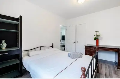 a bedroom with a large white bed and a desk at Comfortable 4B Unit-Close to City Attractions in Montréal