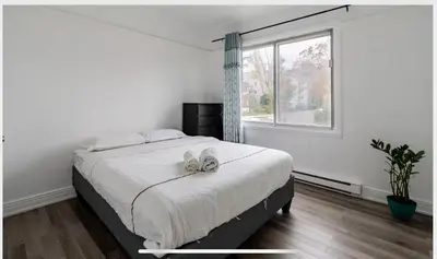 a bedroom with a bed with two white shoes on it at Comfortable 4B Unit-Close to City Attractions in Montréal