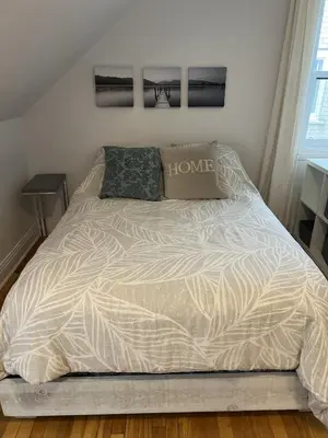 a bed in a bedroom with a white comforter at Montreal cozy entire apartment in Montréal