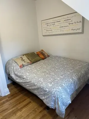 a bed in a bedroom with a sign on the wall at Montreal cozy entire apartment in Montréal