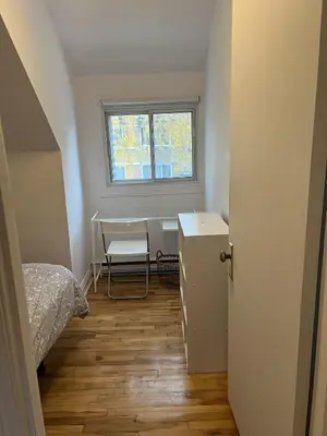 a small room with a bed and a desk and a window at Montreal cozy entire apartment in Montréal