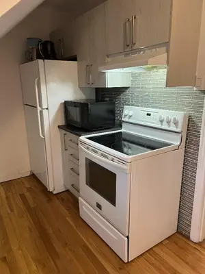 a kitchen with a white stove and a refrigerator at Montreal cozy entire apartment in Montréal