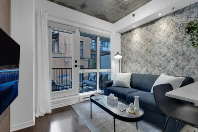 a living room with a blue couch and a window at Dreaming at the Base of the Mountain With Parking in Montréal