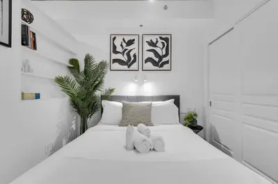 a white bedroom with two stuffed animals on a bed at Dreaming at the Base of the Mountain With Parking in Montréal