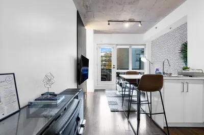 a kitchen with a counter and a table with chairs at Pristine Parc Avenue Pad With Parking in Montréal
