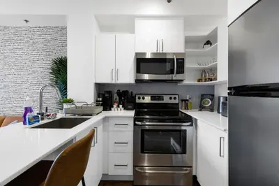 a kitchen with a stainless steel stove and microwave at Pristine Parc Avenue Pad With Parking in Montréal