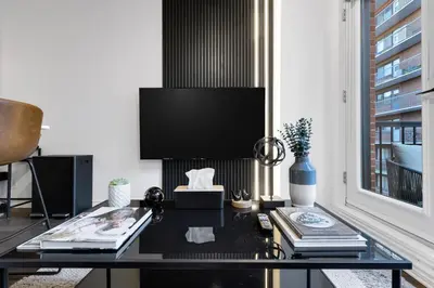a living room with a black table and a tv at Pristine Parc Avenue Pad With Parking in Montréal