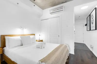 a white bedroom with a large bed with white pillows at Pristine Parc Avenue Pad With Parking in Montréal