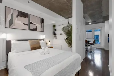 a bedroom with a large white bed in a room at Impeccable Parc Avenue Pad With Parking in Montréal