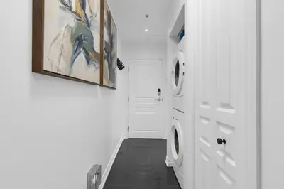 a laundry room with a washer and dryer next to a door at Impeccable Parc Avenue Pad With Parking in Montréal