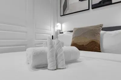 a pile of towels sitting on top of a bed at Impeccable Parc Avenue Pad With Parking in Montréal