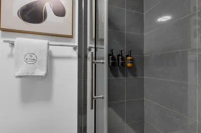 a bathroom with a shower with a glass door at Impeccable Parc Avenue Pad With Parking in Montréal
