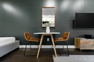 a room with a table and two chairs and a mirror at The Cove Hotel in Montréal
