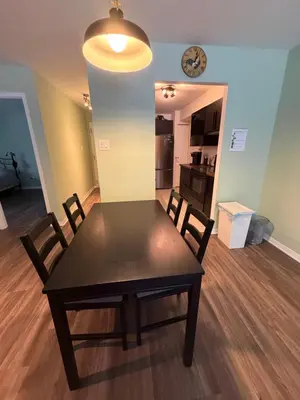 a dining room table with chairs and a clock on the wall at Stunning & Serene Downtown Apartment in Montréal