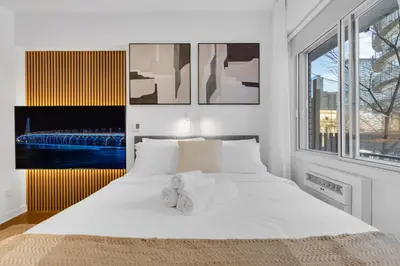 a white bedroom with a large bed with white sheets at The Sherbrooke Suite 101 in Montréal