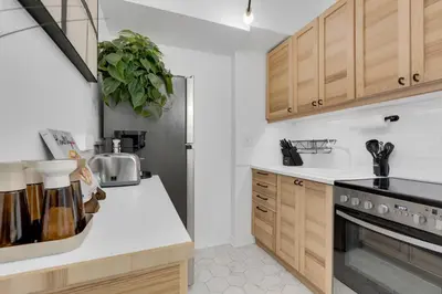 a kitchen with white counter tops and wooden cabinets at The Sherbrooke Suite 101 in Montréal