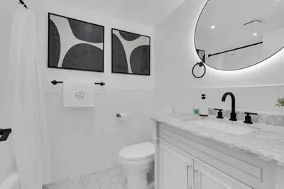 a white bathroom with a toilet and a mirror at The Sherbrooke Suite 101 in Montréal