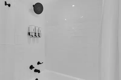 a bathroom with a shower with black shoes on the floor at The Sherbrooke Suite 101 in Montréal