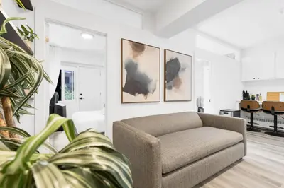 a living room with a couch and paintings on the wall at The Sherbrooke Suite in Montréal