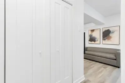 a living room with a couch and a white wall at The Sherbrooke Suite in Montréal