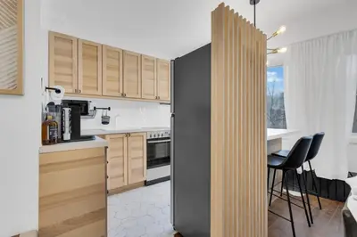 a kitchen with wooden cabinets and a black refrigerator at The Sherbrooke Suite 105 in Montréal