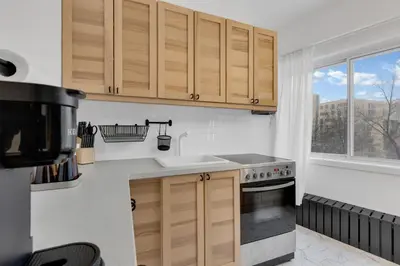 a kitchen with wooden cabinets and a sink and a window at The Sherbrooke Suite 105 in Montréal