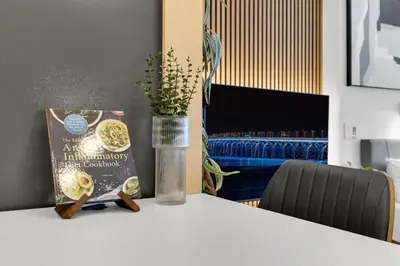 a table with a book and a vase with a plant at The Sherbrooke Suite 99 in Montréal