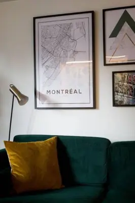 a living room with a green couch and a picture at The Sherbrooke Suite 103 in Montréal