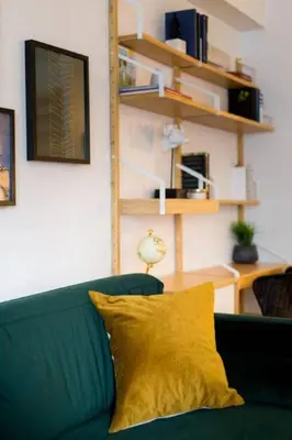 a green couch with a yellow pillow in a living room at The Sherbrooke Suite 103 in Montréal